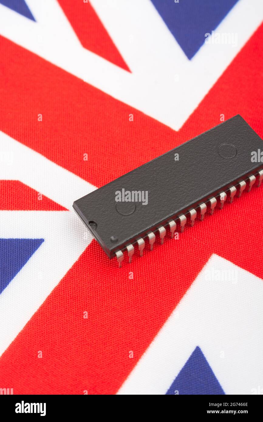 Nahaufnahme des integrierten Schaltkreises/EPROM-Chips auf der kleinen UK Union Jack-Flagge. Bei Halbleitermangel in Großbritannien, Abhängigkeit von britischen Chips, Start-ups von britischen Chips. Stockfoto