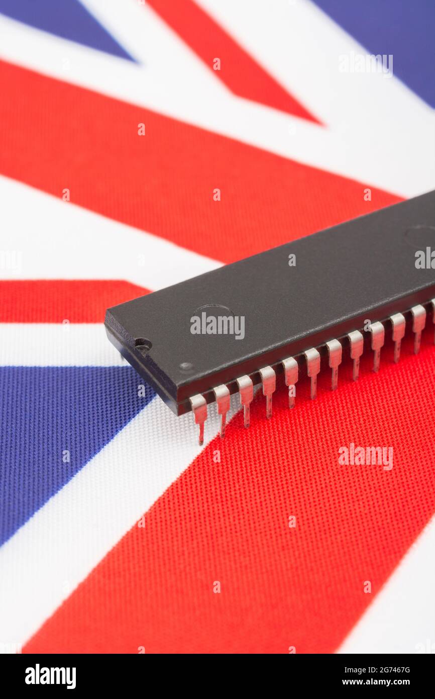 Nahaufnahme des integrierten Schaltkreises/EPROM-Chips auf der kleinen UK Union Jack-Flagge. Bei Halbleitermangel in Großbritannien, Abhängigkeit von britischen Chips, Start-ups von britischen Chips. Stockfoto