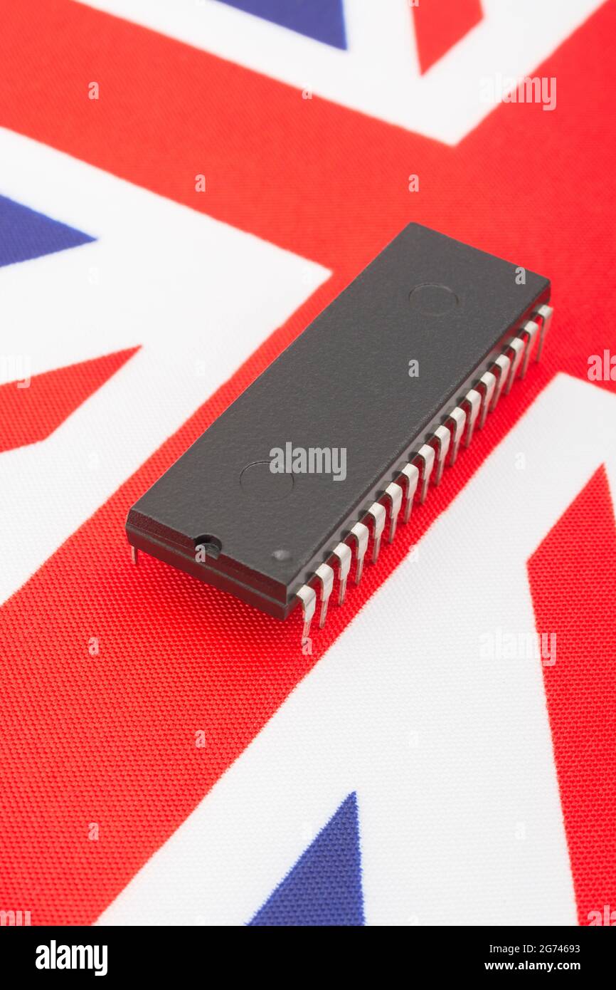Nahaufnahme des integrierten Schaltkreises/EPROM-Chips auf der kleinen UK Union Jack-Flagge. Bei Halbleitermangel in Großbritannien, Abhängigkeit von britischen Chips, Start-ups von britischen Chips. Stockfoto
