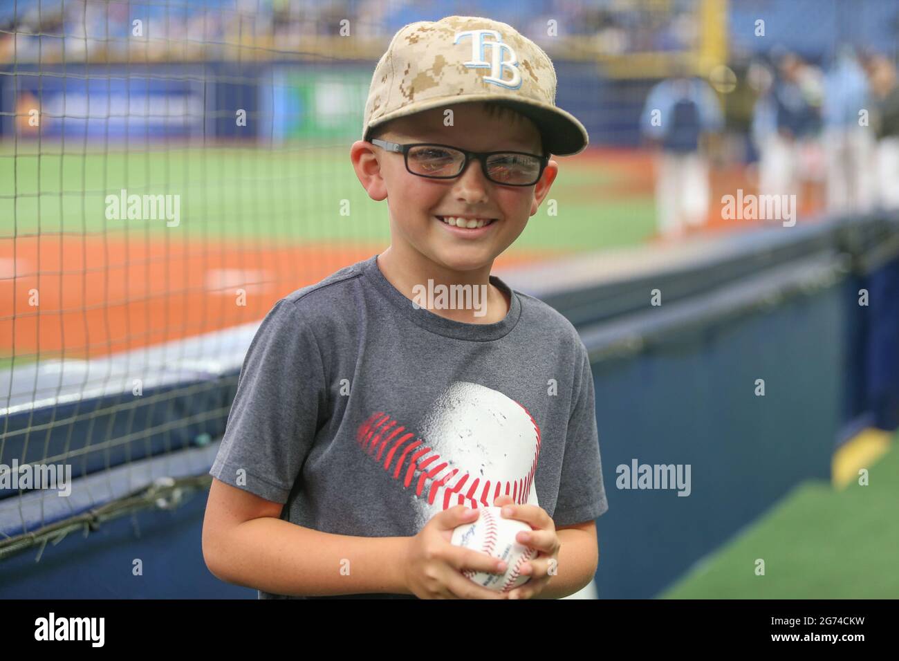 St. Petersburg, Florida. USA; EIN junger Fan erhält einen Baseballschläger von Tampa Bay Rays erstem Base Coach Ozzie Timmons (30) während eines Baseballspiels der Major League Stockfoto