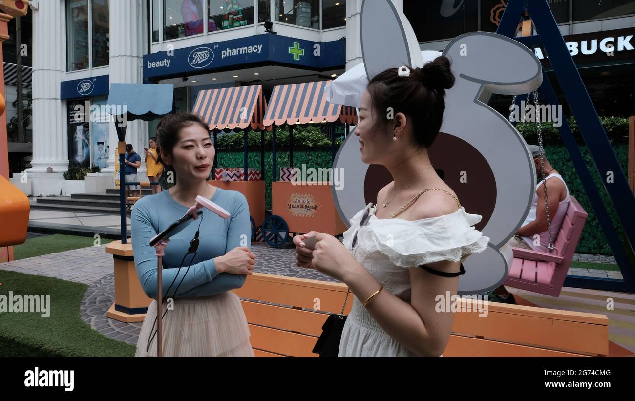 Zwei orientalische Mädchen-Modelle posieren von Weihnachtsdekorationen auf der Sukhumvit Road in Bangkok, Thailand Stockfoto