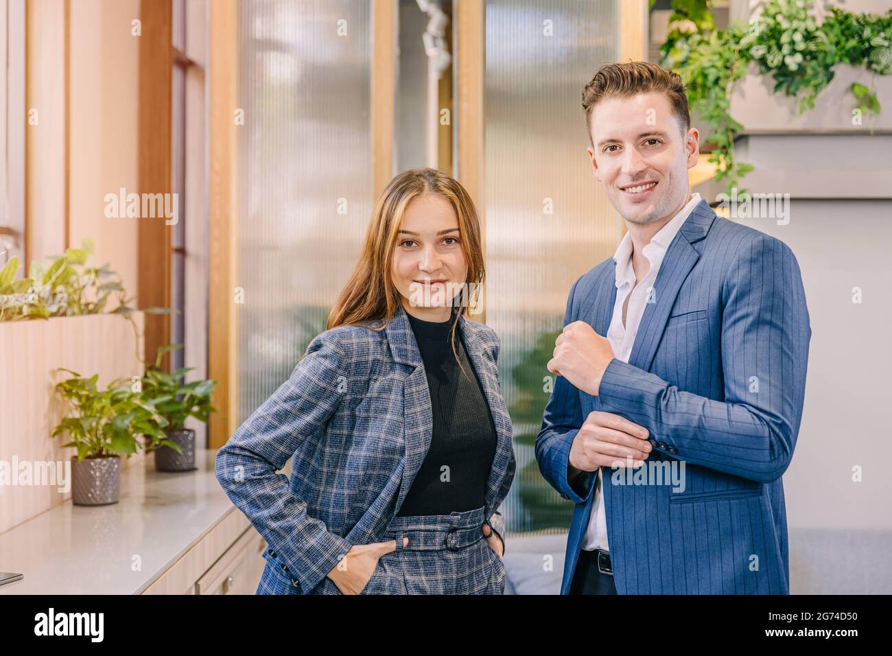 Portrait kaukasischen Geschäftsmann und Frauen stehen zusammen in modernen Büro mit britischen Anzug Mode Kleidung Stil glücklich lächeln. Stockfoto