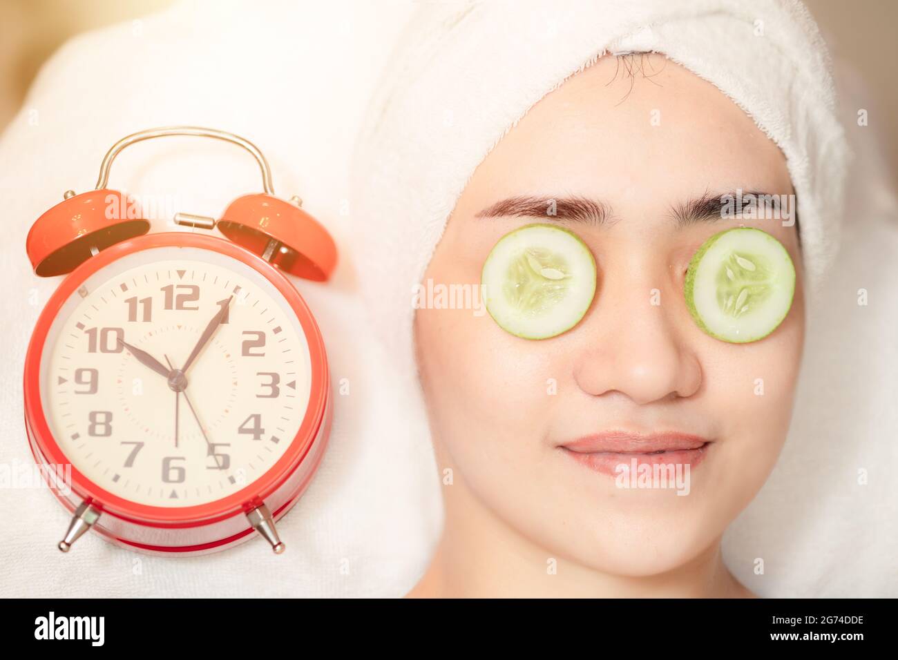 Gesichtsbehandlung für Frauen im Spa mit Uhrzeit. Beauty Times kehrt zu gesunder Haut um Baby Face Anti Aging kosmetisches Konzept. Stockfoto