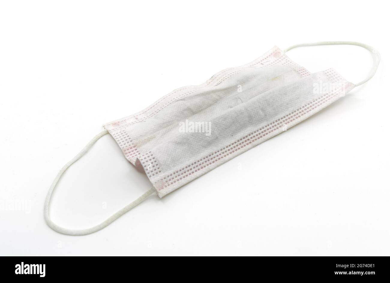 Medizinische Maske auf weißem Hintergrund verwendet. Studio Schuss verwendet und schmutzige medizinische Maske auf weißem Boden. Stockfoto