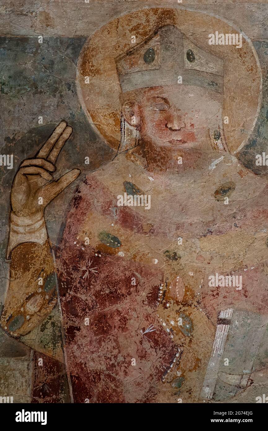 Der Heilige Bischof macht eine Hand-Geste des Segens. Spätmittelalterliches Fresko Mitte der 1300er Jahre Chiesa oder Chiesetta di San Tommaso Apostolo (Kirche des Apostels Thomas) in Cavedago, Trentino-Südtirol, Italien. Stockfoto