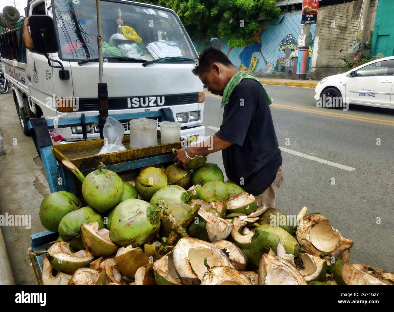 Mandaue City, Philippinen; 28. Juli 2016 -- vor der Pandemie Schauplatz eines umherziehenden Verkäufers, der Kokosfleisch und Kokoswasser auf seinem Wagen verkaufte. Stockfoto