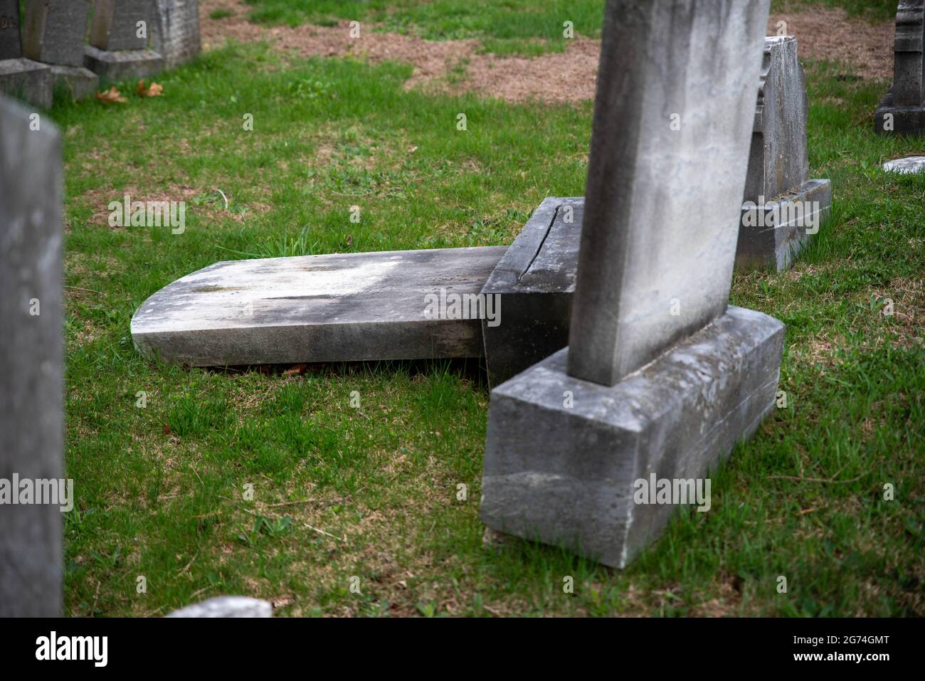 Gestürzt alten Grabstein Grabstein gr4een Gras Friedhof Stockfoto