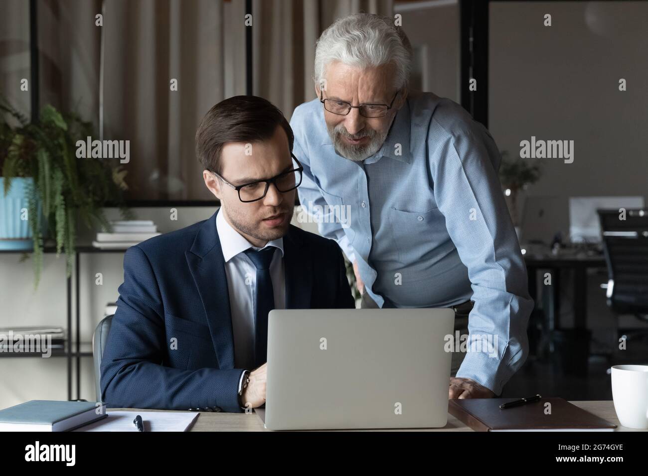 Ältere Berufstätiger, die Hilfe geben, Ratschläge für junge Mitarbeiter Stockfoto