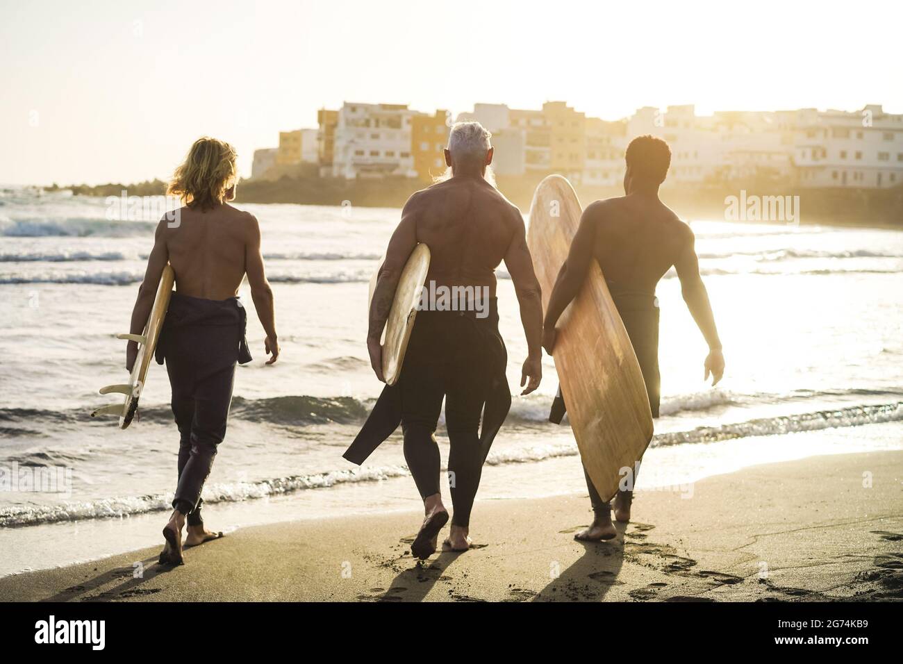 Surferfreunde mit mehreren Generationen haben Spaß beim Surfen am Strand - Schwerpunkt auf Senioren Stockfoto