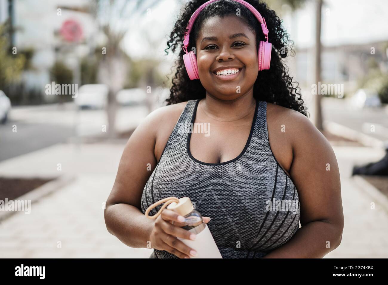 Sport kurvige schwarze Frau Musik hören mit Kopfhörern - Fokus auf Gesicht Stockfoto