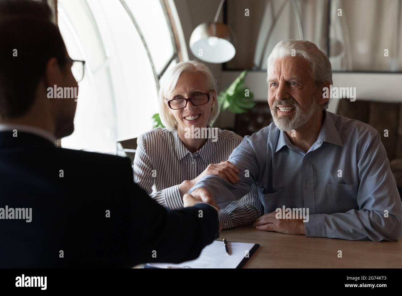 Glücklich dankbar ältere paar Kunden danken Immobilienmakler Stockfoto