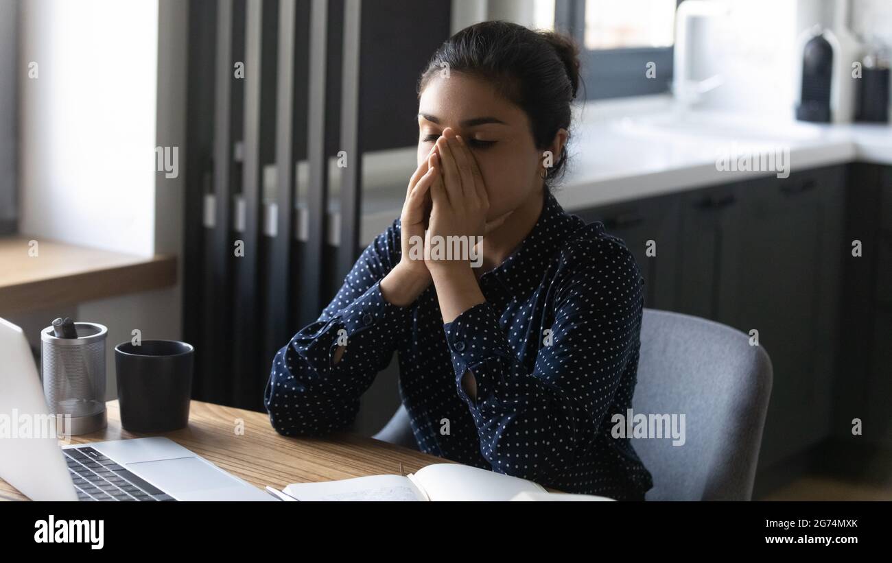 Müde überarbeiteter indischer Mitarbeiter, der Müdigkeit und Burnout spürte Stockfoto