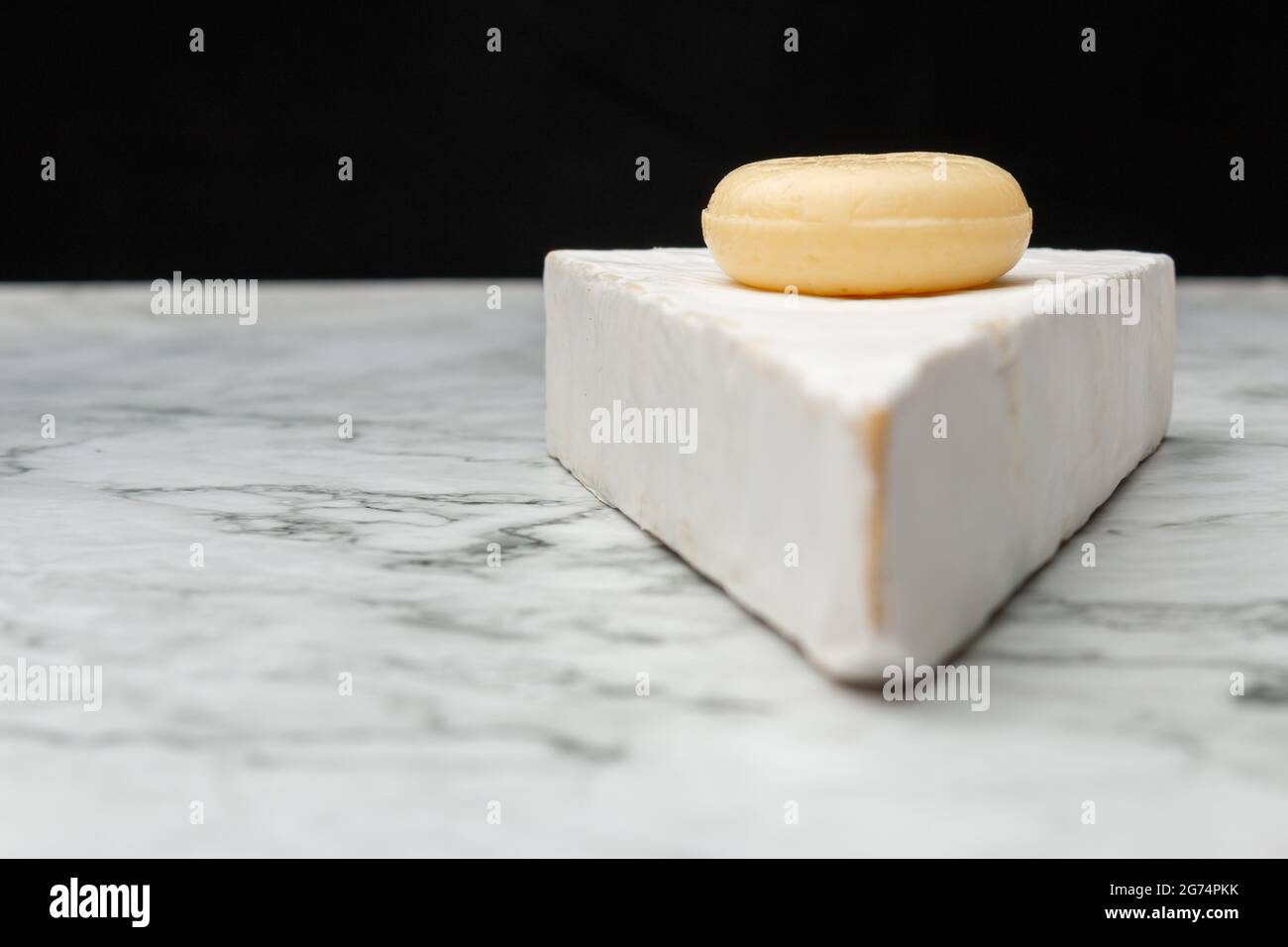 Ein Nahaufnahme Bild von weißem Akawi-Käse mit rundem, kleinen Käse darauf auf einer Marmoroberfläche Stockfoto