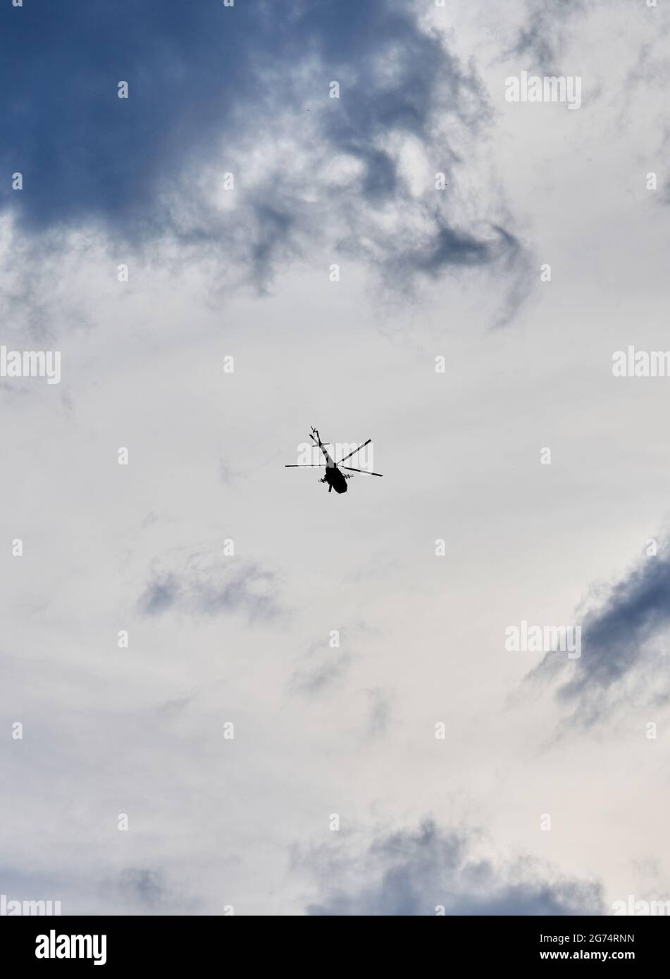 Militärhubschrauber der russischen Streitkräfte fliegt in den Himmel mit Strukturwolken. Tag der Marine Russlands. Marineparade. Die Feiertage von Sankt Petersburg, Russ Stockfoto