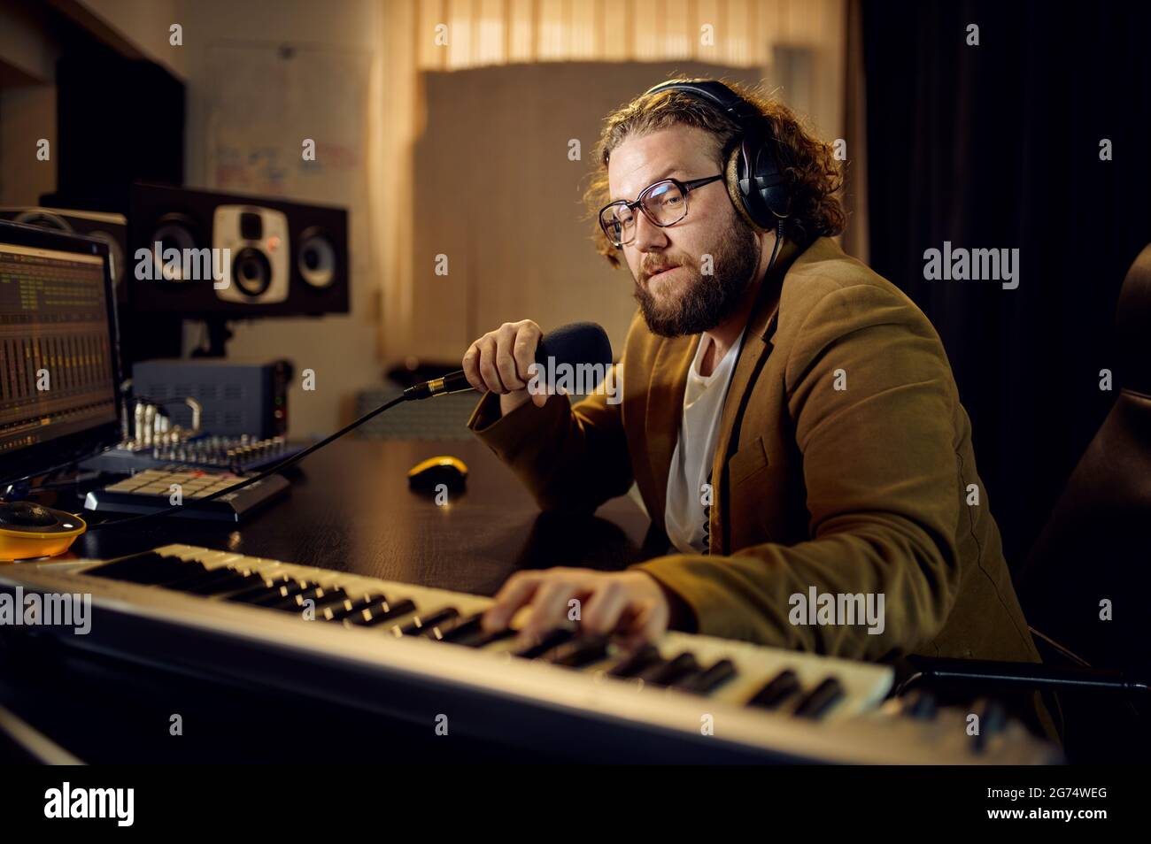 Toningenieur hält Mikrofon, Aufnahmestudio Stockfoto