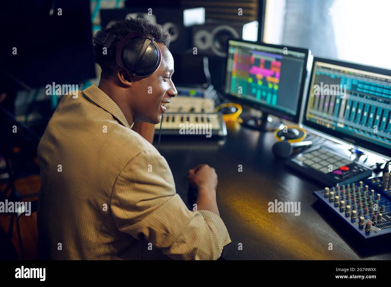 Männlicher dj, der an einem neuen Hit-Aufnahmestudio arbeitet Stockfoto