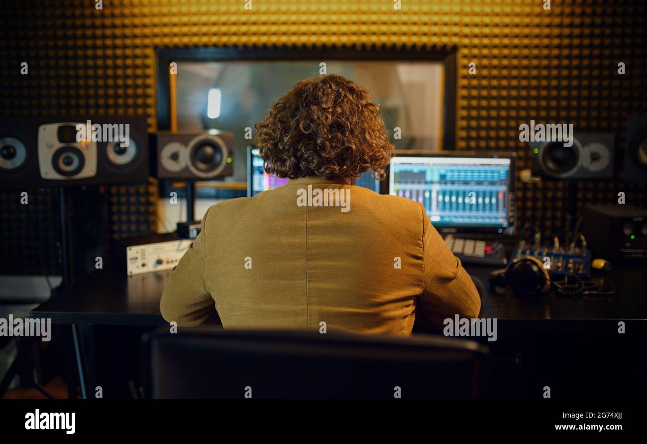 Männlicher Toningenieur beim Mischen von Consol, Rückansicht Stockfoto