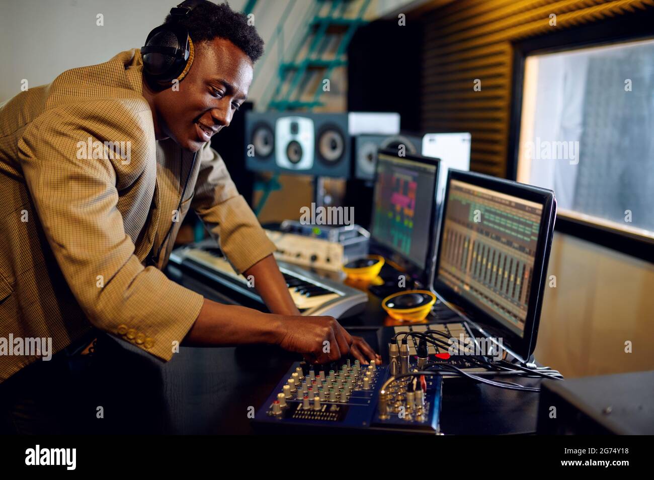 Männlicher dj, der eine Platte hört, Studio aufnimmt Stockfoto