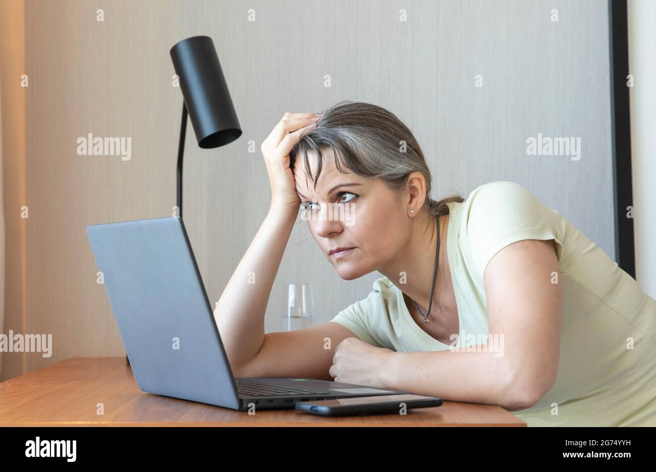Frau mittleren Alters langweilen sich bei der Arbeit von zu Hause aus Stockfoto