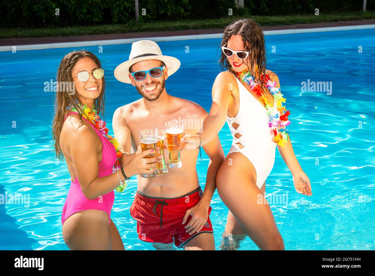Frauen und Männer feiern das Trinken auf einer Poolparty Stockfoto