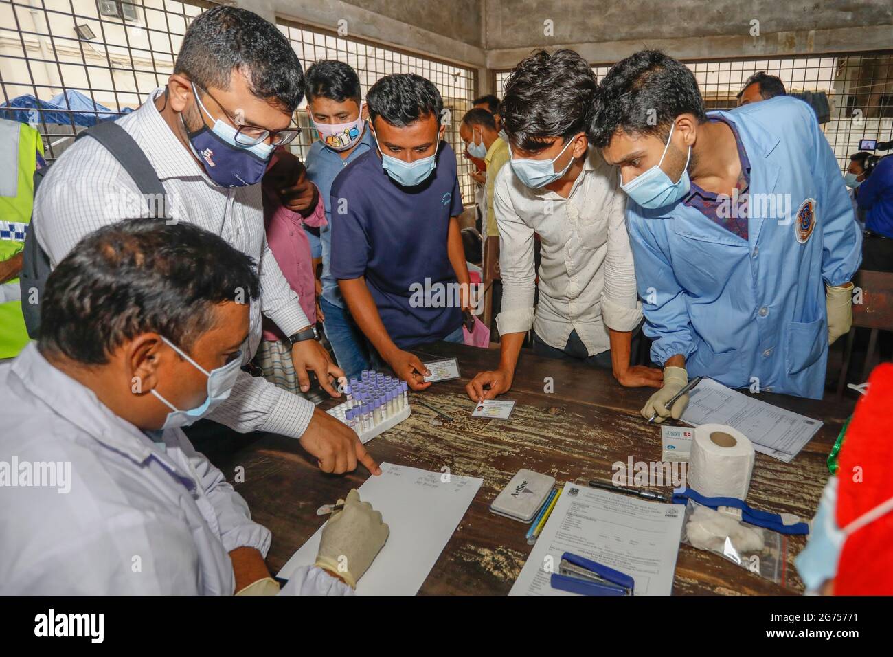 Angehörige der Opfer fordern ihren Namen im Krankenhaus der Dhaka Medical College an, während medizinische Beamte Blutproben von den Verwandten der V. Stockfoto