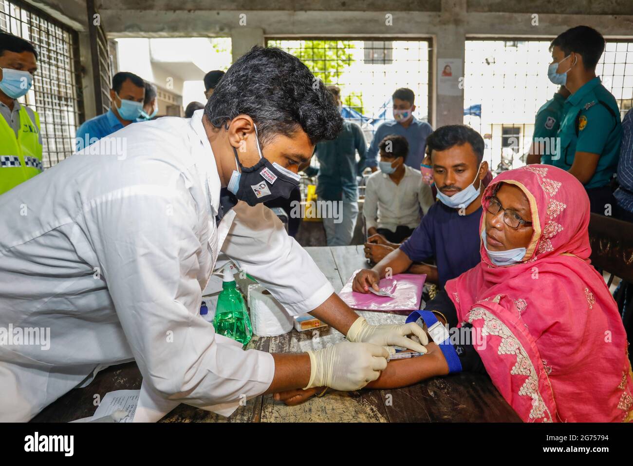 Ein medizinischer Offizier sammelt Blutproben von den Verwandten der Opfer des Fabrikfeuers von Narayanganj Hashem Foods Ltd. Für DNA-Tests in Dhaka M Stockfoto