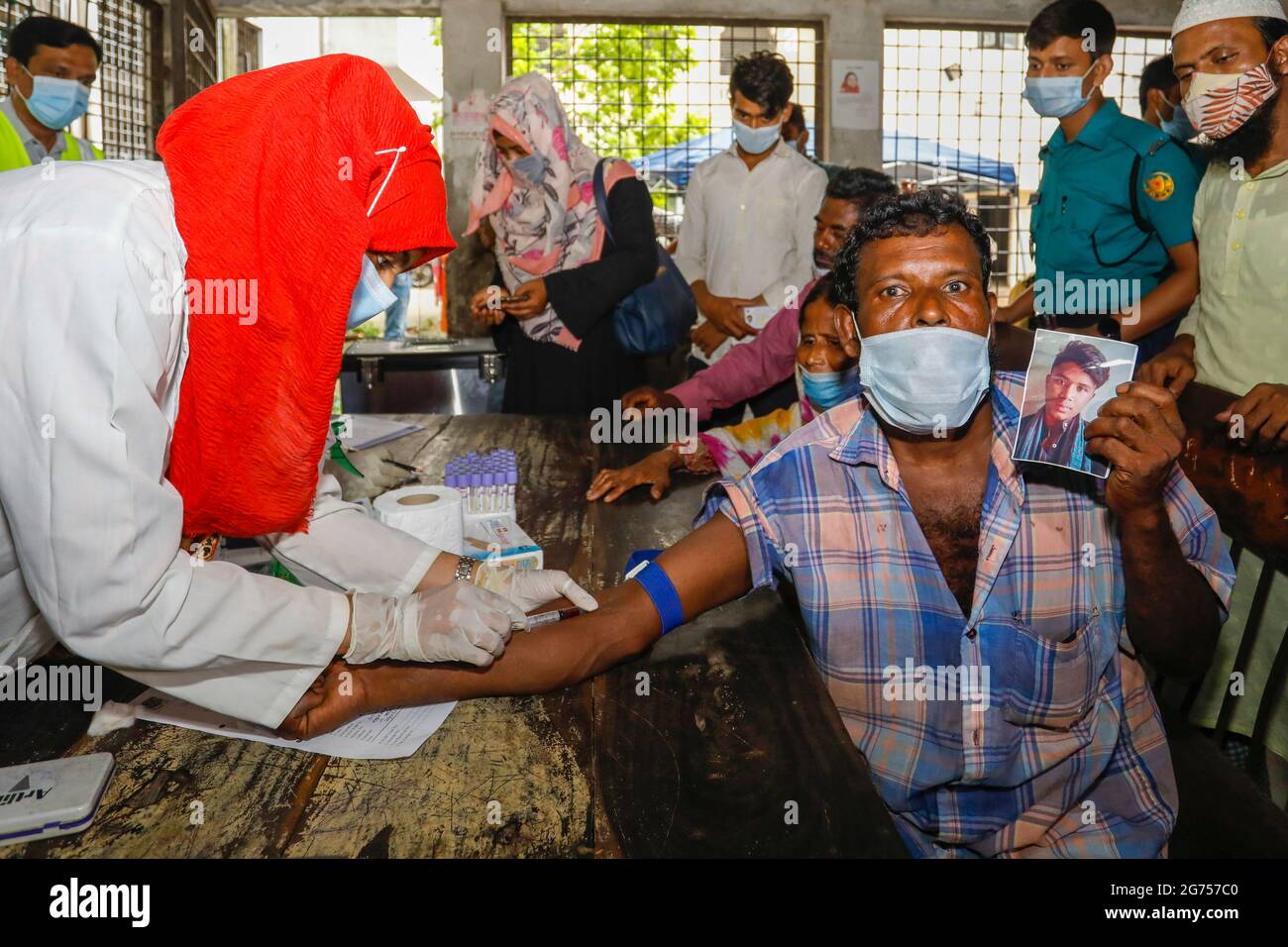 Ein medizinischer Offizier sammelt Blutproben von den Verwandten der Opfer des Fabrikfeuers von Narayanganj Hashem Foods Ltd. Für DNA-Tests in Dhaka M Stockfoto
