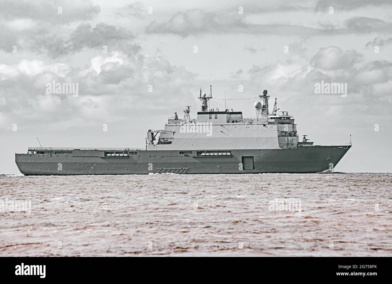 Großes graues modernes Kriegsschiff, das in stillem Wasser segelt. Stockfoto