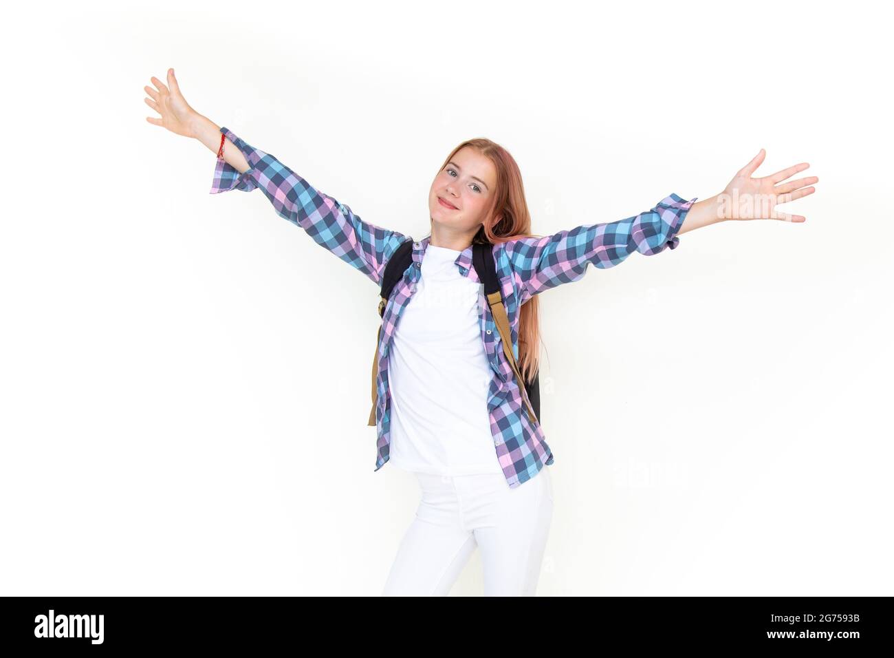 Teenager Mädchen 11 Jahre alt Schuljunge Blick auf die Kamera auf einem weißen Hintergrund mit einem Rucksack und lächelnd hält ihre Hände hoch. In pla gekleidet Stockfoto