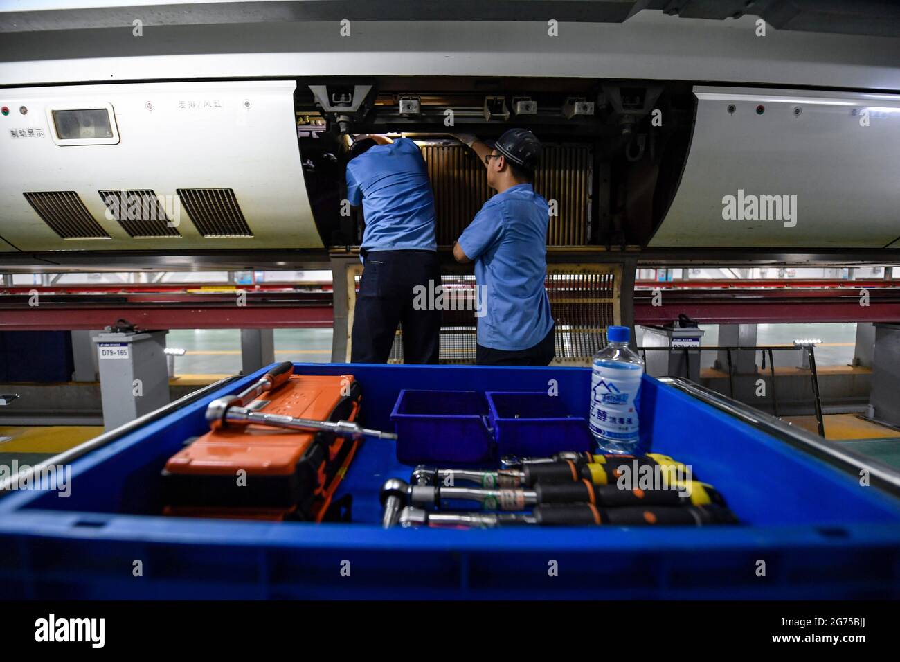 (210711) -- YINCHUAN, 11. Juli 2021 (Xinhua) -- Mechaniker inspizieren einen Hochgeschwindigkeitszug auf einer Wartungsbasis in Yinchuan, nordwestlich der Autonomen Region Ningxia Hui, 10. Juli 2021. China Railway Lanzhou Bureau Group Co., Ltd. Hat täglich Wartungsarbeiten für Züge durchgeführt, um die Zugsicherheit in der Sommerhitze zu gewährleisten. (Xinhua/Feng Kaihua) Stockfoto
