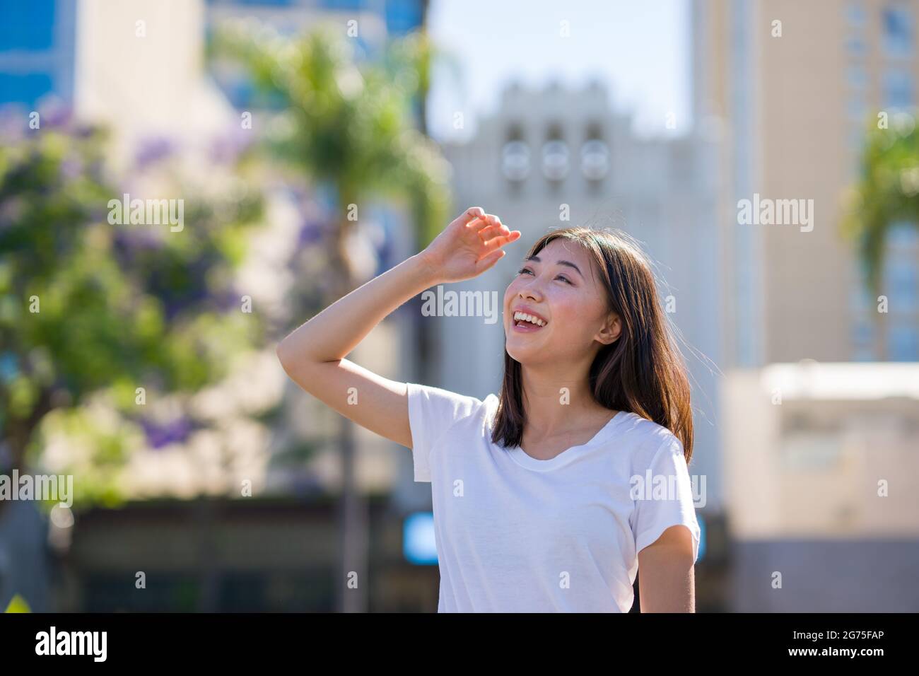 Porträts einer jungen asiatischen Frau, die auf einem Parkplatz in der Innenstadt läuft Stockfoto