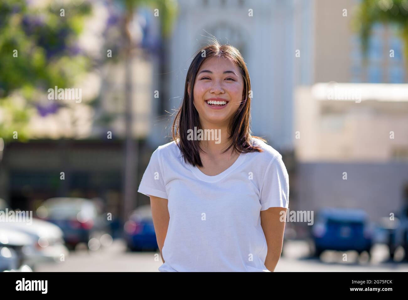 Porträts einer jungen asiatischen Frau, die auf einem Parkplatz in der Innenstadt läuft Stockfoto