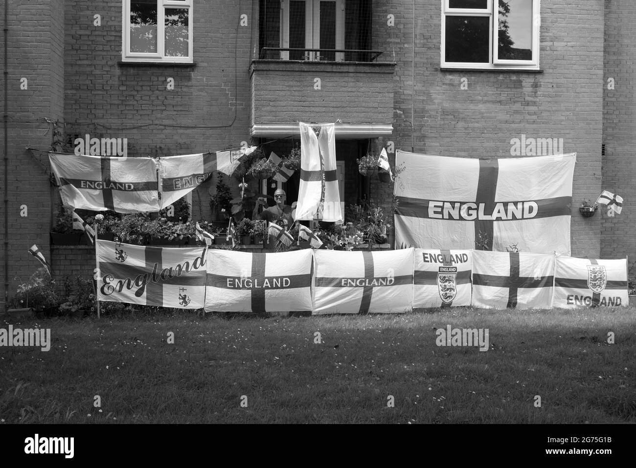 In ganz England zeigen die Menschen ihre Farben und wünschen sich eine Wiederholung der WM 1966. Ein Mann kleidet sein Haus in Flaggen, um England beim Gewinn der UEFA-Fußball-Europameisterschaft zu unterstützen. Stockfoto