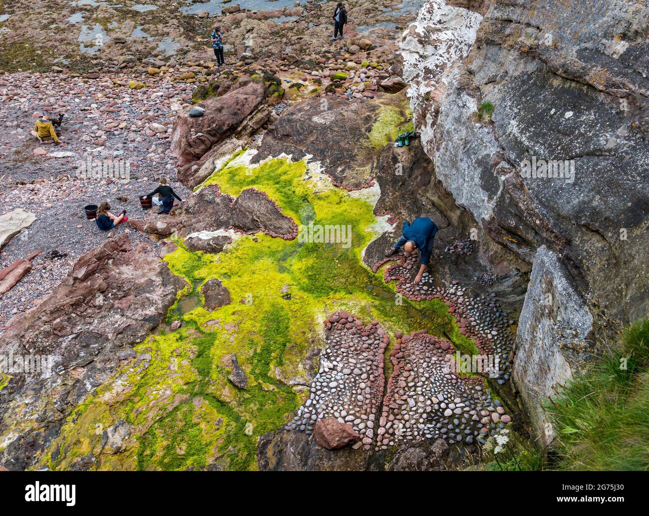 Dunbar, East Lothian, Schottland, Großbritannien, 11. Juli 2021. European Stone Stacking Championship: Am zweiten und letzten Tag treten die Landkünstler in einer künstlerischen Herausforderung an, in der sie 4 Stunden Zeit haben, um eine Felsskulptur zu erschaffen. Im Bild: Teilnehmer Mark Anthony Haden Ford Stockfoto