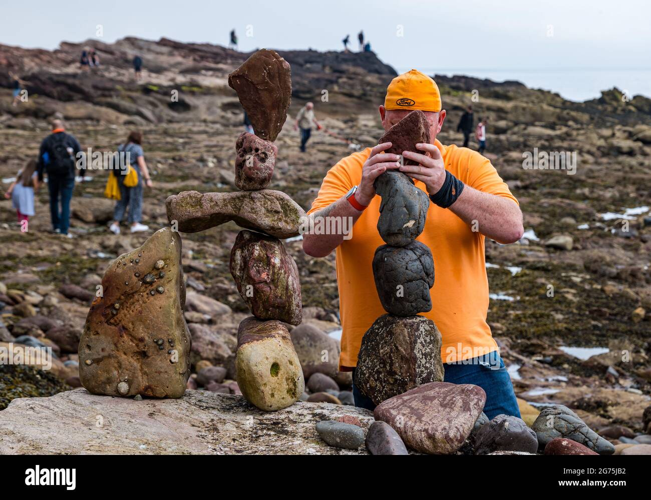 Dunbar, East Lothian, Schottland, Großbritannien, 11. Juli 2021. European Stone Stacking Championship: Am zweiten und letzten Tag treten die Landkünstler in einer künstlerischen Herausforderung an, in der sie 4 Stunden Zeit haben, um eine Felsskulptur zu erschaffen. Im Bild: Teilnehmer Dicey Turnbull Stockfoto