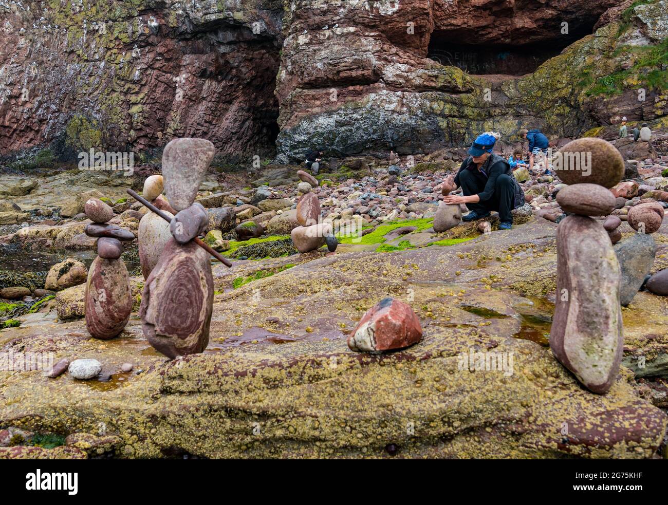 Dunbar, East Lothian, Schottland, Großbritannien, 11. Juli 2021. European Stone Stacking Championship: Am zweiten und letzten Tag treten die Landkünstler in einer künstlerischen Herausforderung an, in der sie 4 Stunden Zeit haben, um eine Felsskulptur zu erschaffen. Im Bild: Steinbilanzen der Teilnehmerin Caroline Walker, die in der Regel Arbeiten im Wasser erstellt, die hier so konzipiert sind, dass sie bei Flut zusammenbrechen Stockfoto