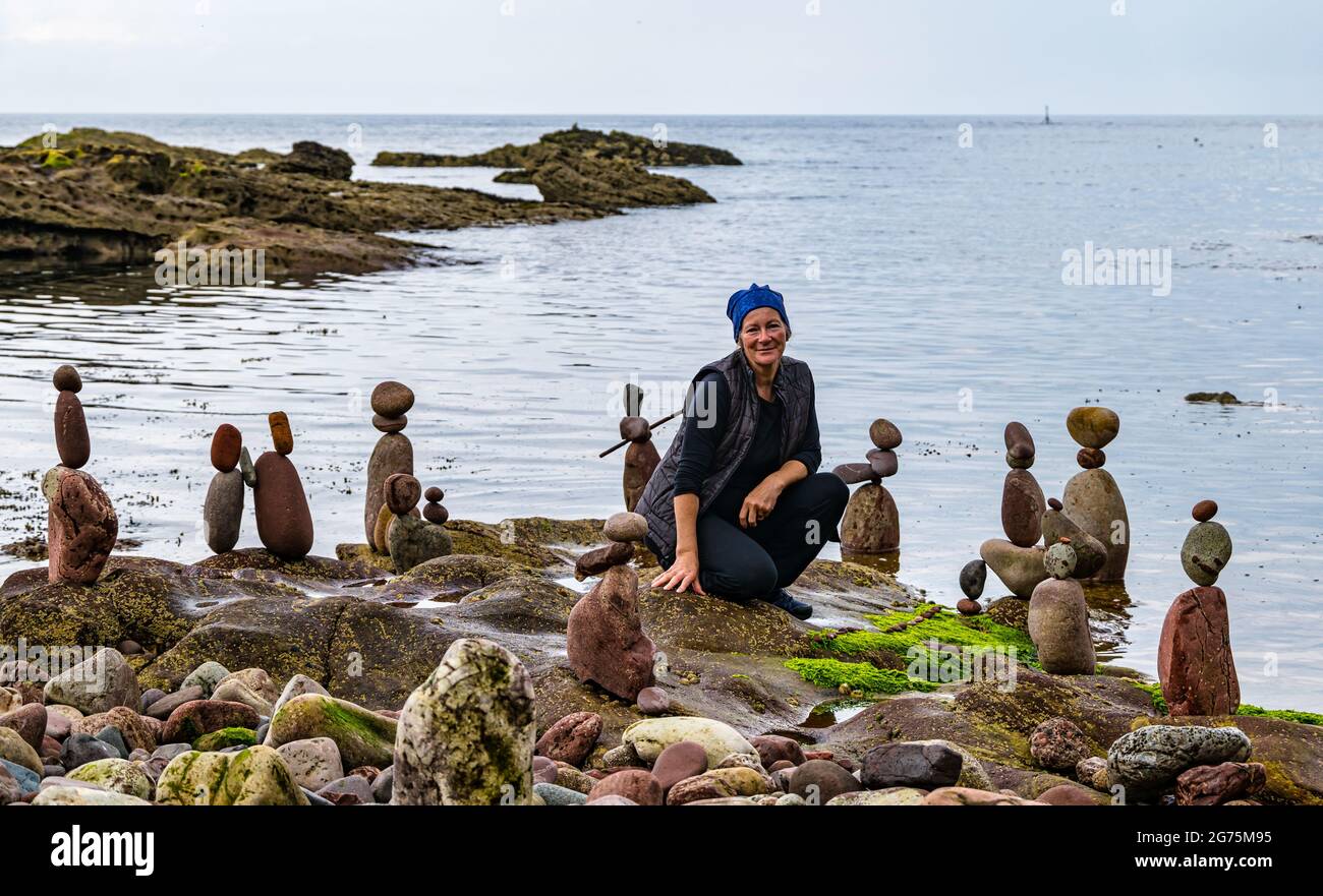 Dunbar, East Lothian, Schottland, Großbritannien, 11. Juli 2021. European Stone Stacking Championship: Am zweiten und letzten Tag treten die Landkünstler in einer künstlerischen Herausforderung an, in der sie 4 Stunden Zeit haben, um eine Felsskulptur zu erschaffen. Im Bild: Steinbilanzen der Teilnehmerin Caroline Walker, die in der Regel Arbeiten im Wasser erstellt, die hier so konzipiert sind, dass sie bei Flut zusammenbrechen Stockfoto