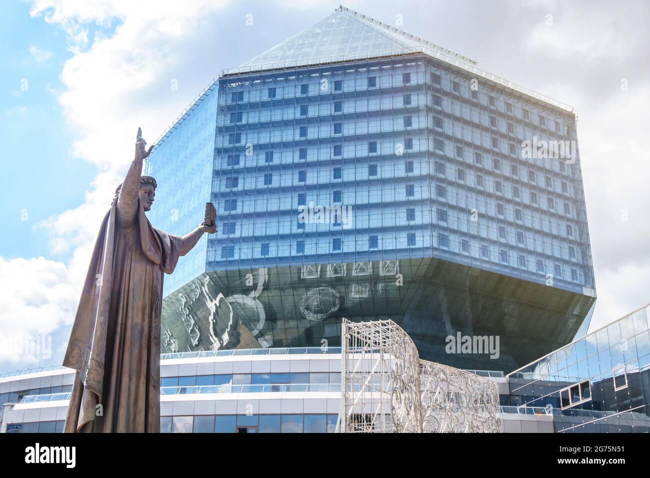 MINSK, WEISSRUSSLAND - 26. JUNI 2021: Denkmal von Francysk Skaryna mit Blick auf das Gebäude der Nationalbibliothek in Minsk, Weißrussland. Stockfoto