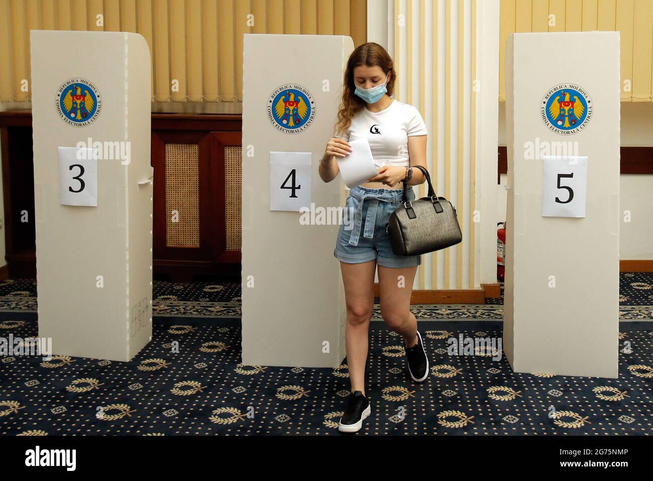 Bukarest, Rumänien. Juli 2021. Eine in Rumänien lebende moldauische Staatsbürgerin wählt in einem Wahllokal in Bukarest, Rumänien, am 11. Juli 2021 ihre Stimme. Rund 3 Millionen Wähler der Republik Moldau sind am Sonntag aufgerufen, ihre Stimme bei vorgezogenen Parlamentswahlen abzusetzen, bei denen 20 politische Parteien, zwei Blöcke und ein unabhängiger Kandidat gegeneinander antreten. Quelle: Cristian Cristel/Xinhua/Alamy Live News Stockfoto