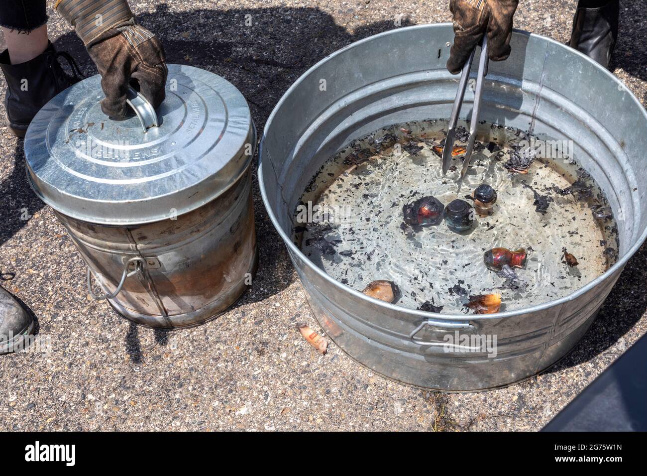 Detroit, Michigan - Mitglieder des Pewabic Pottery Street Teams demonstrieren die japanische Technik des Raku-Feuers von Töpferwaren auf einem Gemeinschaftskunstwerk und einem Mu Stockfoto