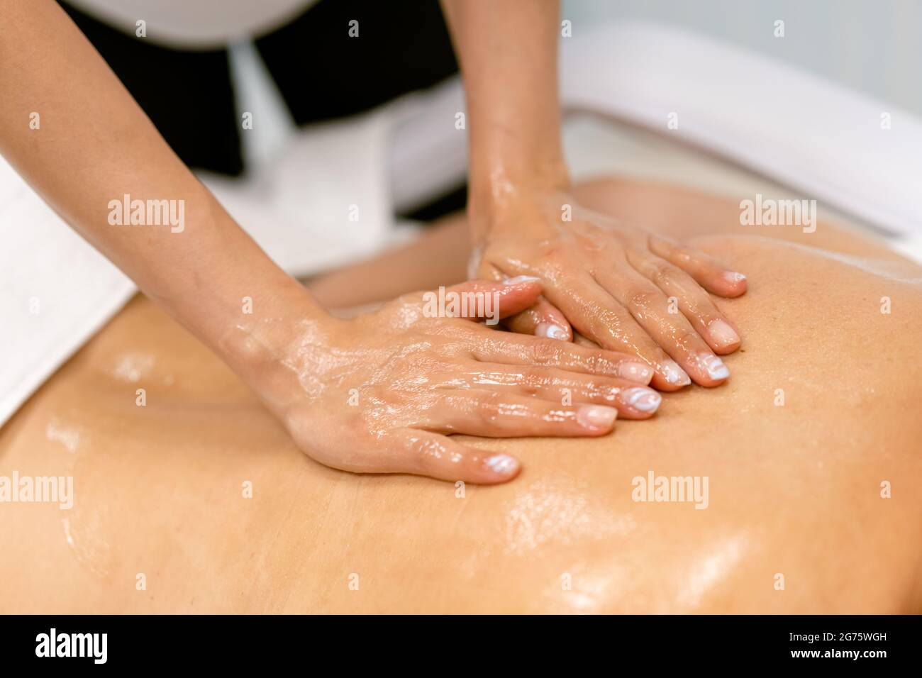 Frau erhält eine Rückenmassage mit Massagekerzenöl. Stockfoto