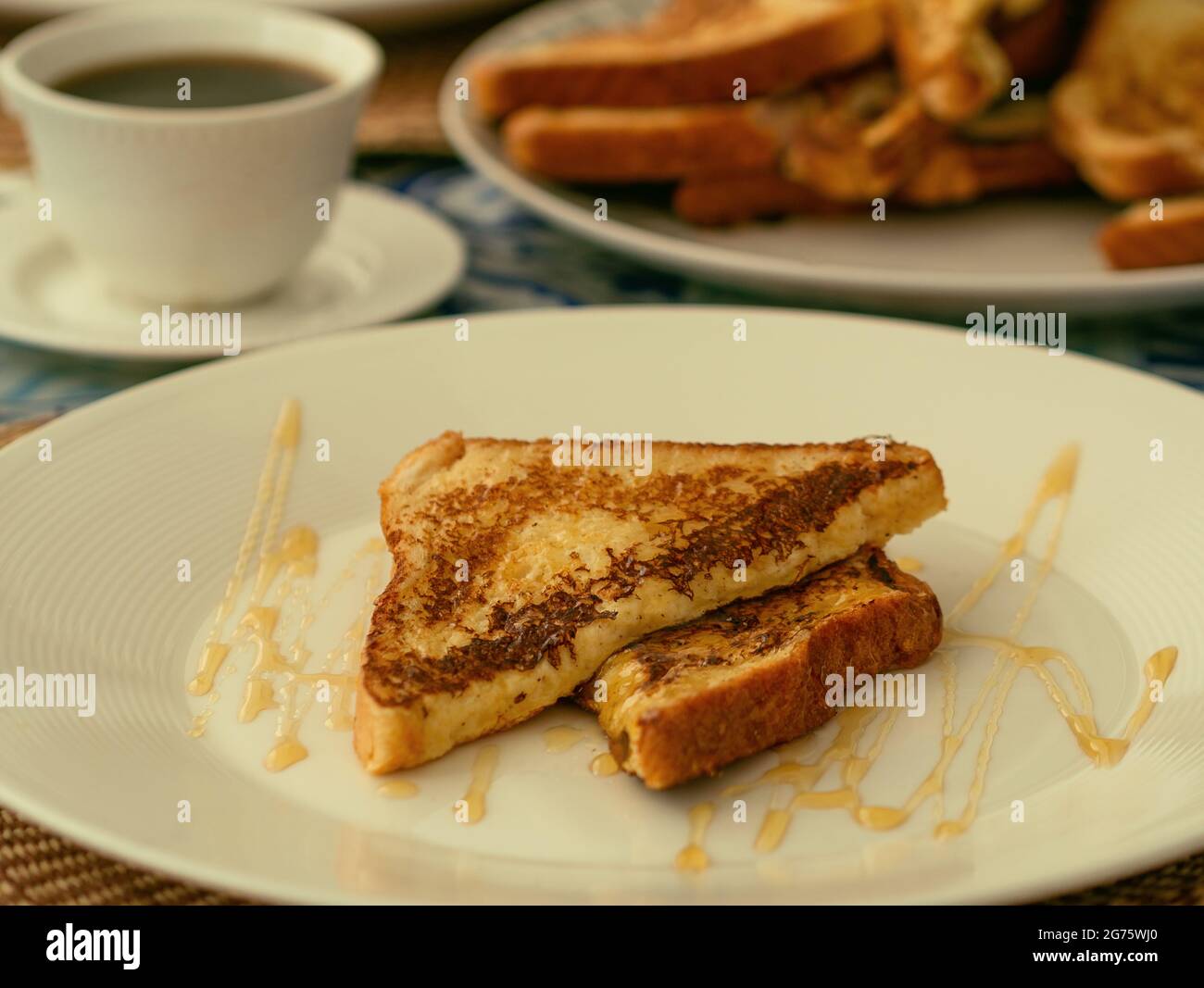 Zwei French Toast mit Honig, serviert auf einem weißen Teller zum Frühstück oder Brunch Stockfoto
