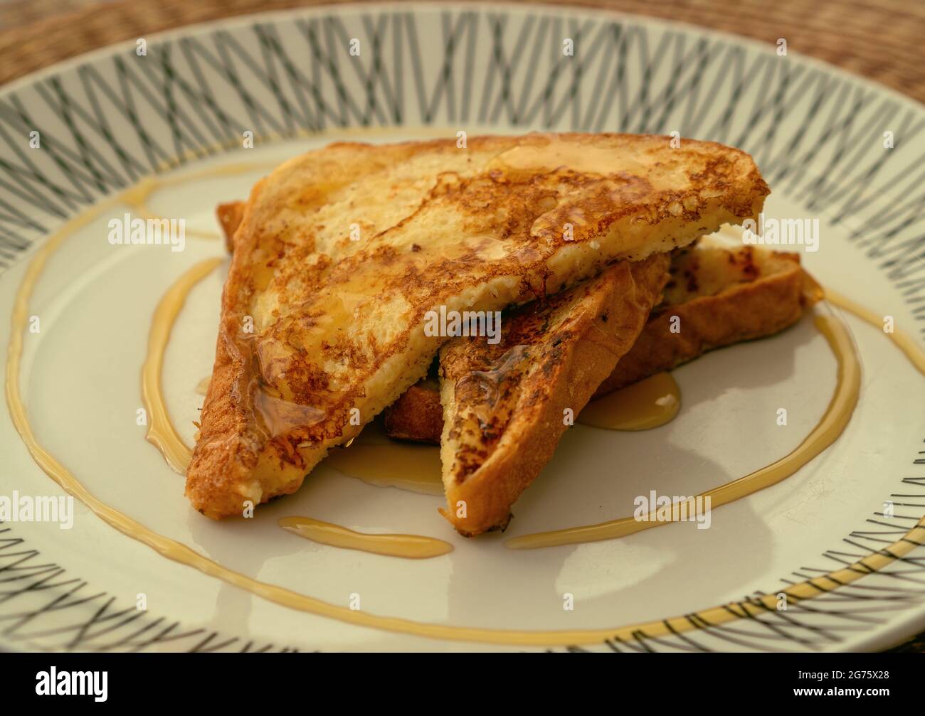 Zwei French Toast mit Honig, serviert auf einem weißen Teller zum Frühstück oder Brunch Stockfoto
