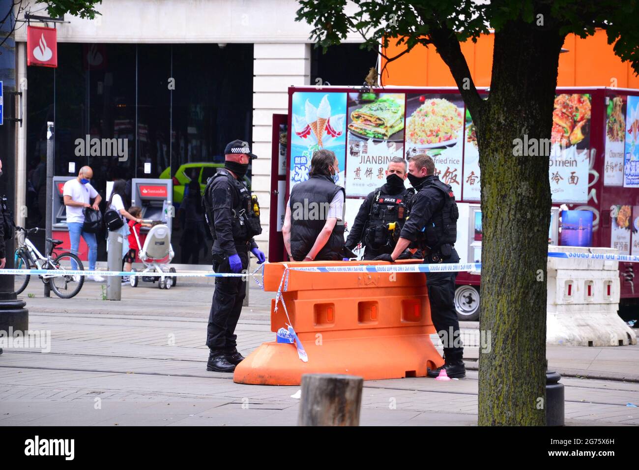 Polizeivorfall und Cordon in Piccadilly Gardens, Manchester, England, UK, am Sonntag, den 11. Juli 2021, um 15.13 Uhr. Polizisten sprechen mit einem Mann, der anscheinend Handschellen hat. Ein PCSO-Beamter dachte, der Vorfall sei ein Messerstecher, aber das ist nicht bestätigt. Stockfoto