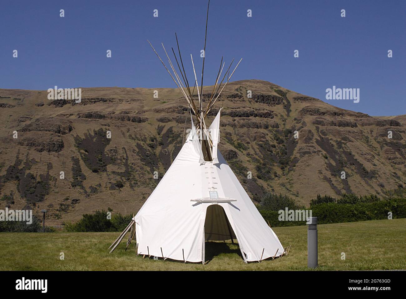 SPALDING / BUNDESSTAAT IDAHO / USA . Flagge der Vereinigten Staaten und indischer Tepe im Nez Perce Musuem, der Spalding-Stätte, entlang des US Highway 95 zum Hauptquartier des Nez Perce National Historical Park, Ein modernes Besucherzentrum bietet eine feine Museumssammlung Filme über die Geschichte der Nez Perce Menschen und einen kleinen Souvenirladen. Das 99 Hektar große Gelände enthält historische Friedhofs und Gebäude, Interpretationsschilder und einen großen Picknickbereich, die heutige Kommunit- und Parkfläche des im Jahr 1897 benannten spaltenden Beamten Ursprünglich Lapwai genannt und diente über 11.000 Jahre als traditioneller Homesit der Thlep-Thlep Weyma Band Stockfoto