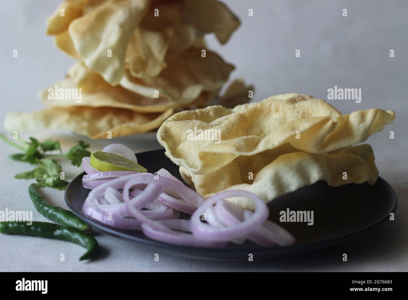 Ein Papadium, auch Papad genannt, ist ein dünnes, knackiges, rundes Fladenbrot aus Indien. Es wird durch Frittieren oder Kochen mit trockener Hitze durch Umdrehen über einen OP hergestellt Stockfoto