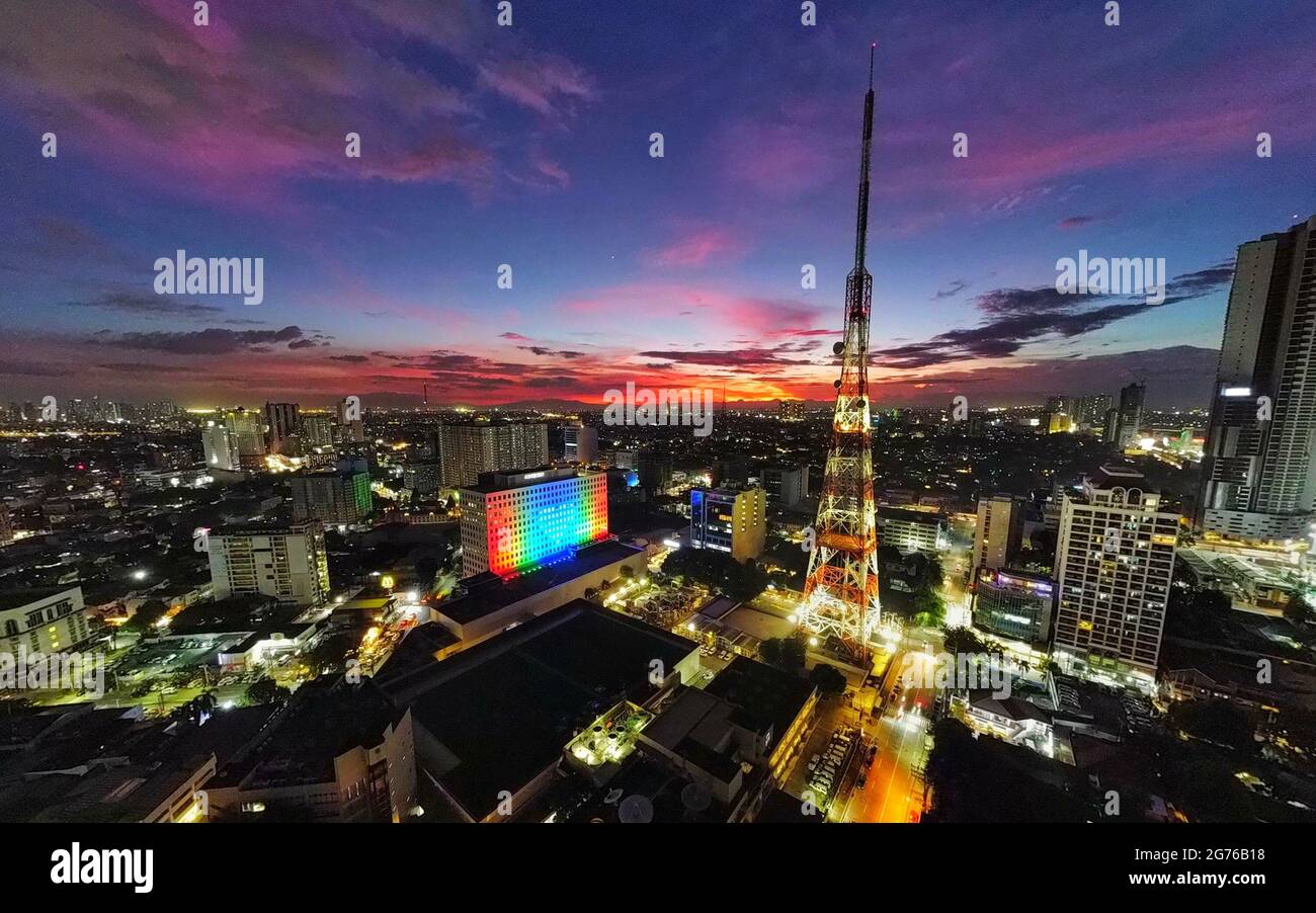 Ein Drohnenbild zeigt das ABS-CBN ELJ-Gebäude, das die Signaturfarben des Unternehmens am Vorabend des ersten Jahrestages der Ablehnung einer neuen Franchise für das Rundfunknetz in Quezon City, Metro Manila, projiziert. Der philippinische Kongress stimmte am 10. Juli 2021 gegen eine neue Franchise für das Multimedia-Netzwerk ABS-CBN, nachdem die 25-jährige Franchise abgelaufen war. Philippinen. Stockfoto