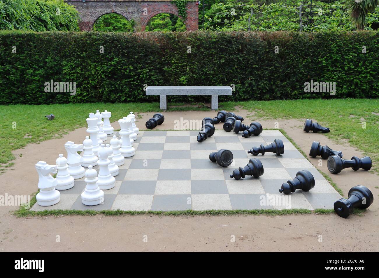 LONDON, VEREINIGTES KÖNIGREICH - 09. Jun 2021: Ein kreatives großes Schachbrett mit verstreuten schwarzen Stücken in Holland Park, London, Vereinigtes Königreich Stockfoto