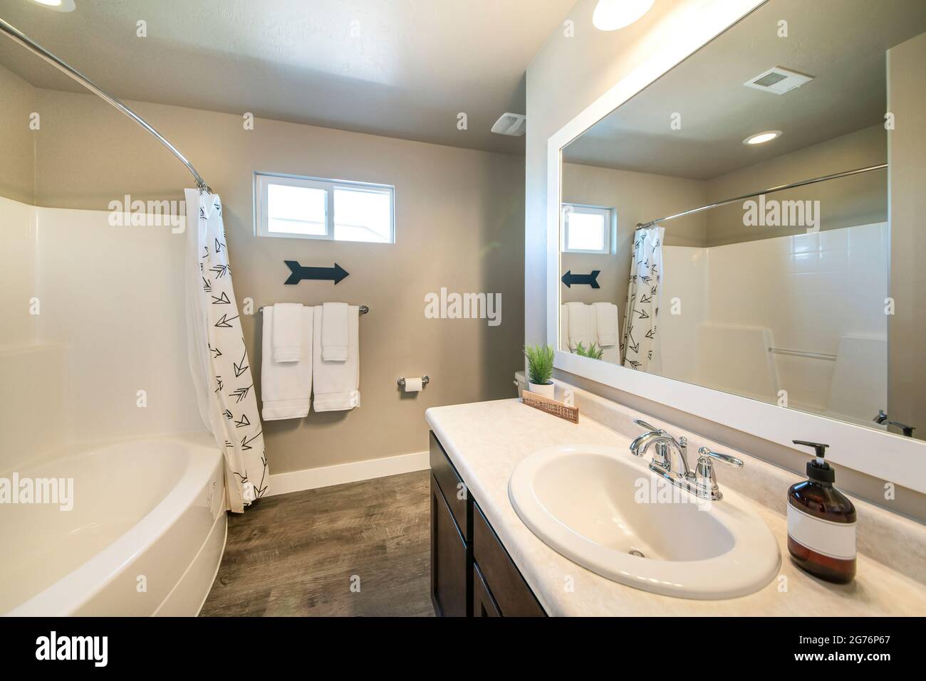 Badezimmer mit Holzboden und dekorativer Pfeilanzeige an der Wand Stockfoto