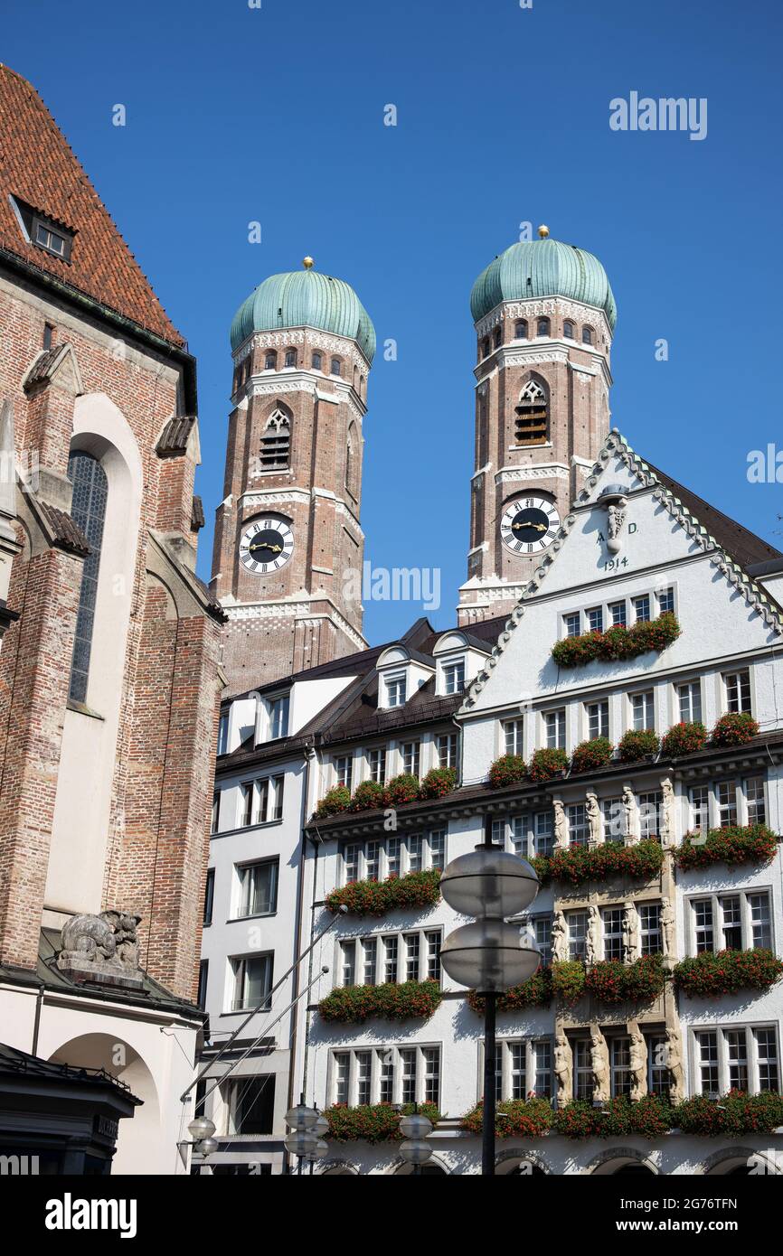 Die Türme der Frauenkirche hinter den Häusern der pdestrianischen Zone im Zentrum von München Stockfoto